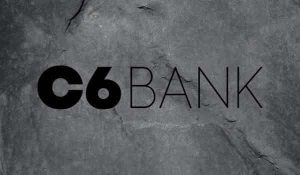 Logo do C6 Bank escrito na cor preta e sobre um fundo cinza.