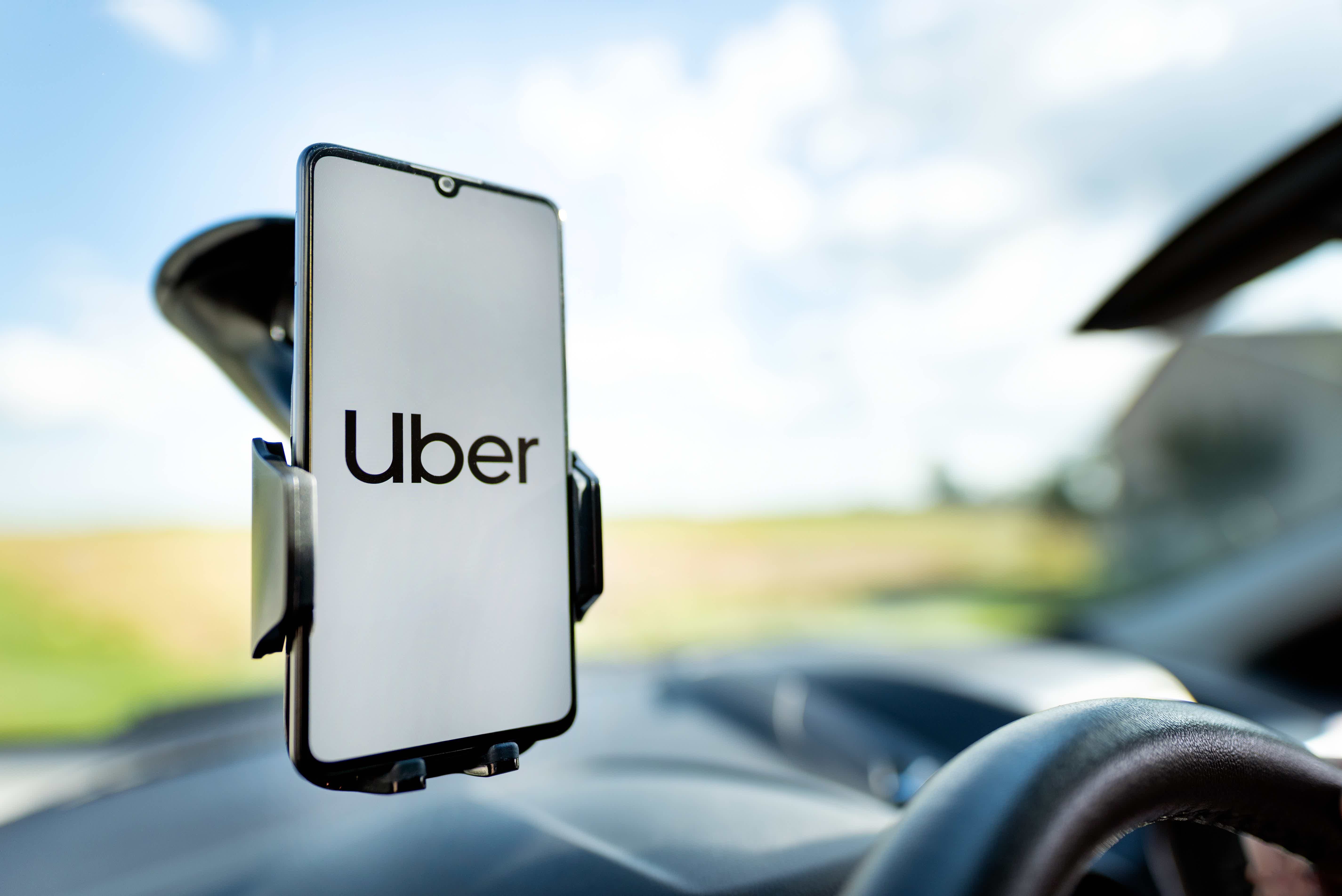 Celular com aplicativo Uber preso em vidro de carro com suporte