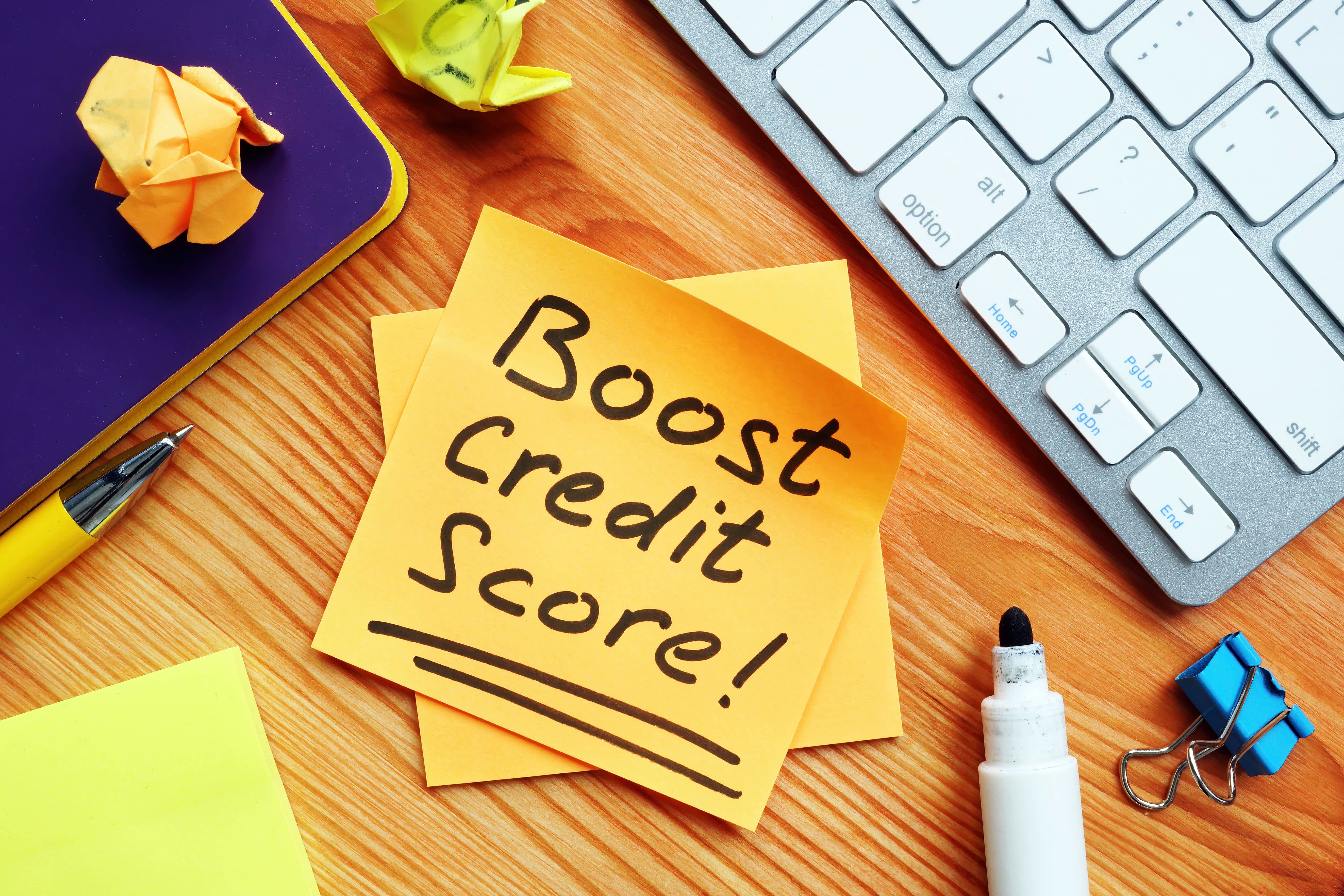 post-it with the words: boost credit score