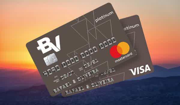 Imagem ilustrativa de dois cartões BV Platinum, sendo um de bandeira Visa e um Mastercard. Ao fundo, temos uma paisagem de montanhas com o sol nascendo no horizonte.
