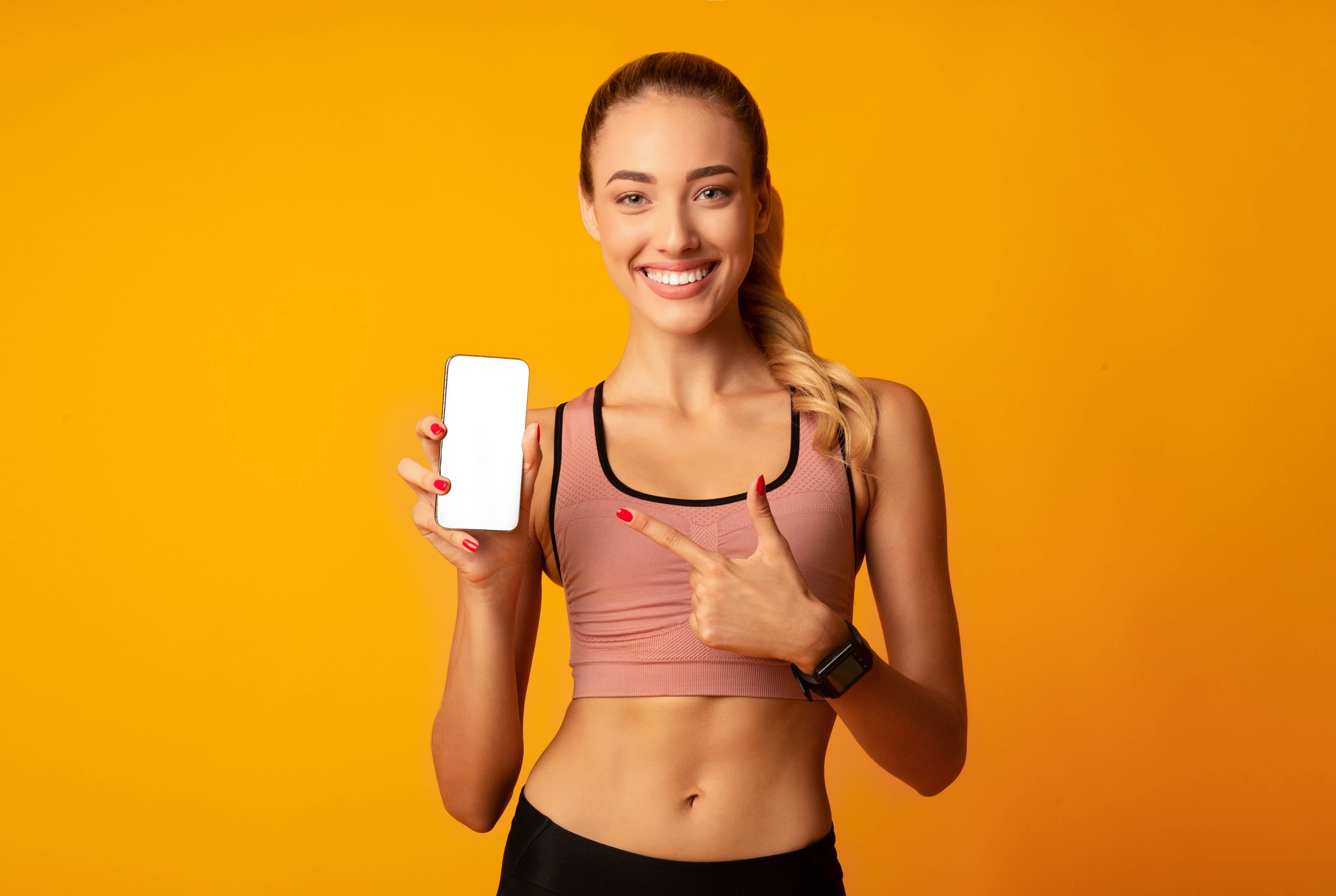 Mulher fitness segurando celular