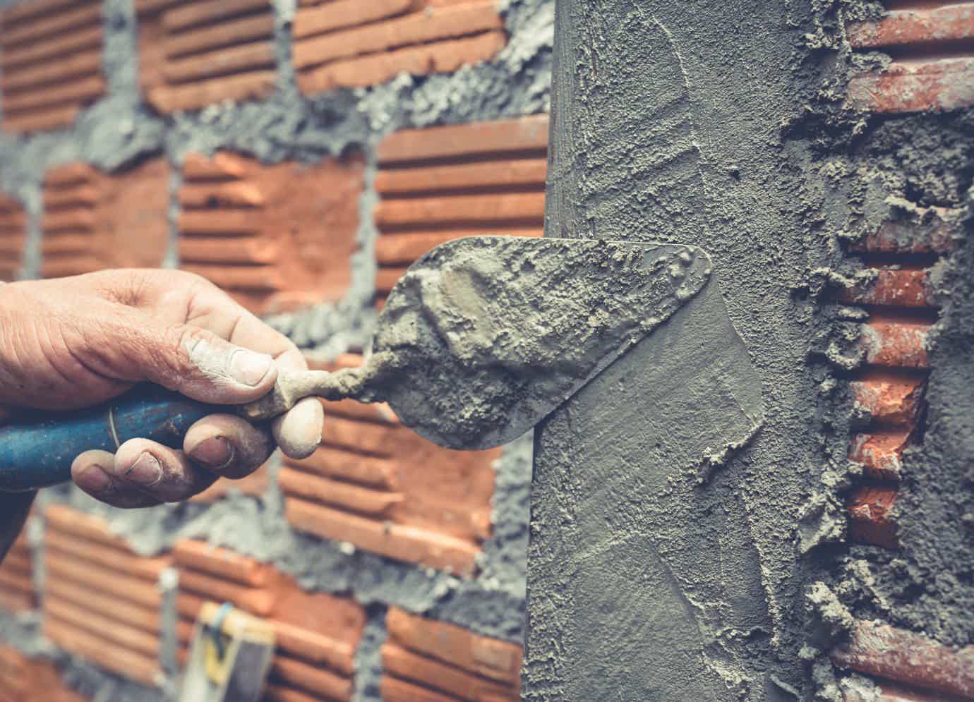 colocando cimento no muro