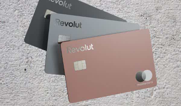 Cartão Revolut Premium na cor coral à frente da imagem com outros modelos do mesmo cartão mais ao fundo abertos como um leque.