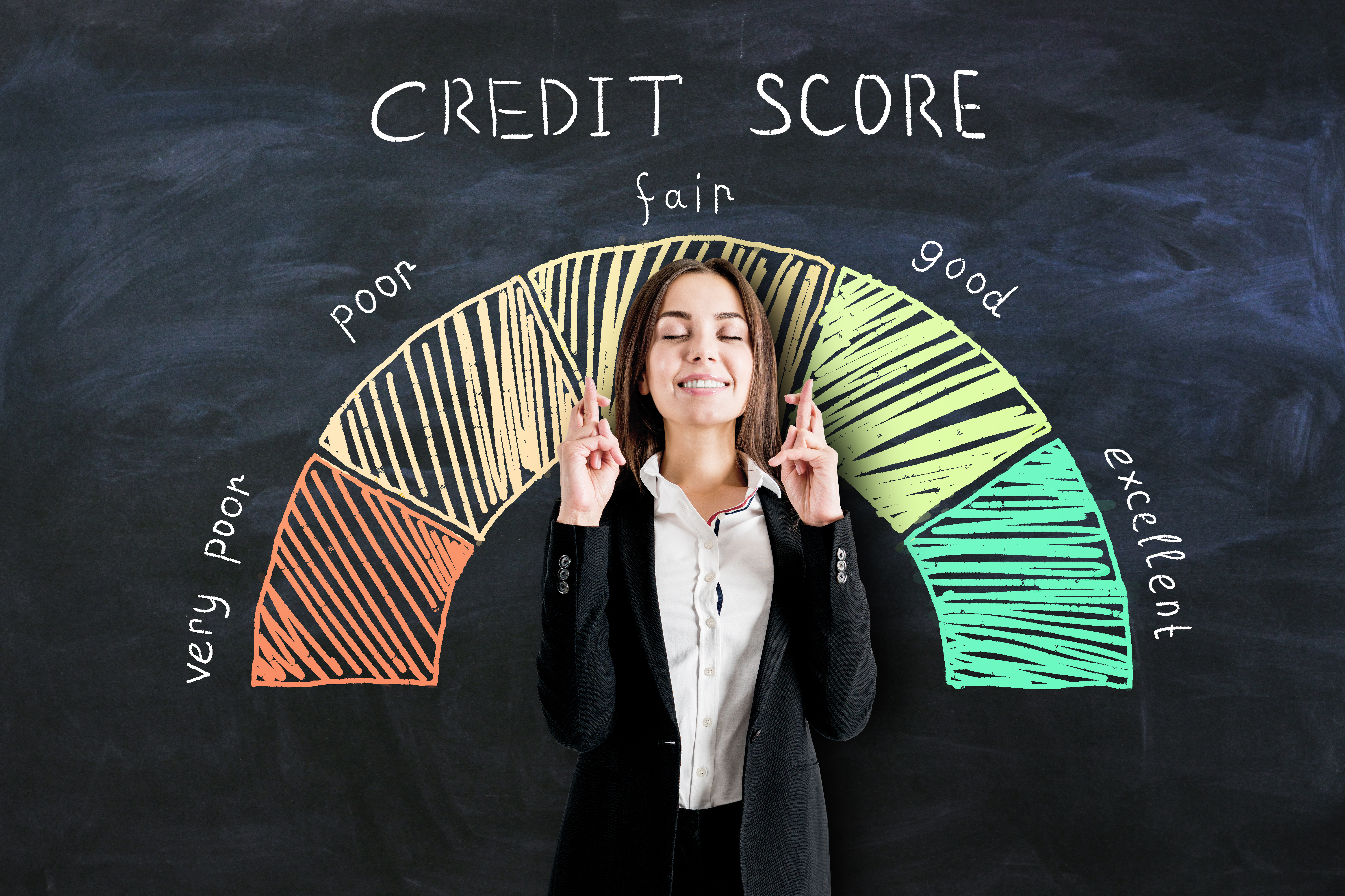 woman crossing her fingers while standing in front of a credit score meter