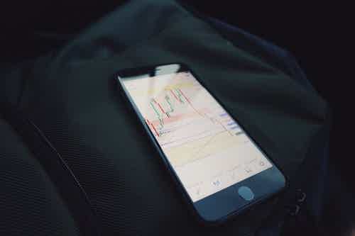 smartphone in black background showing investment platform