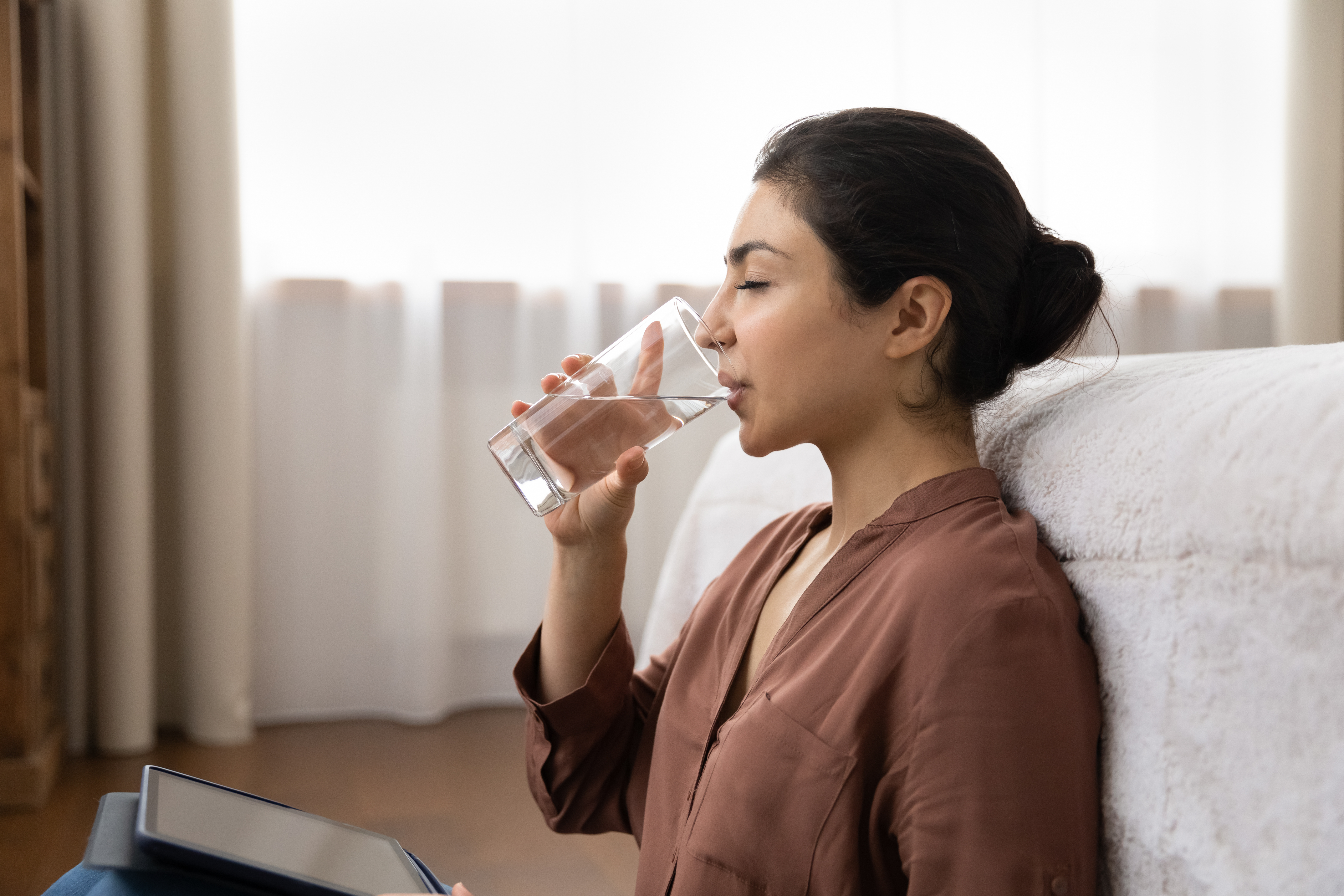 Mulher sentada bebendo copo de água