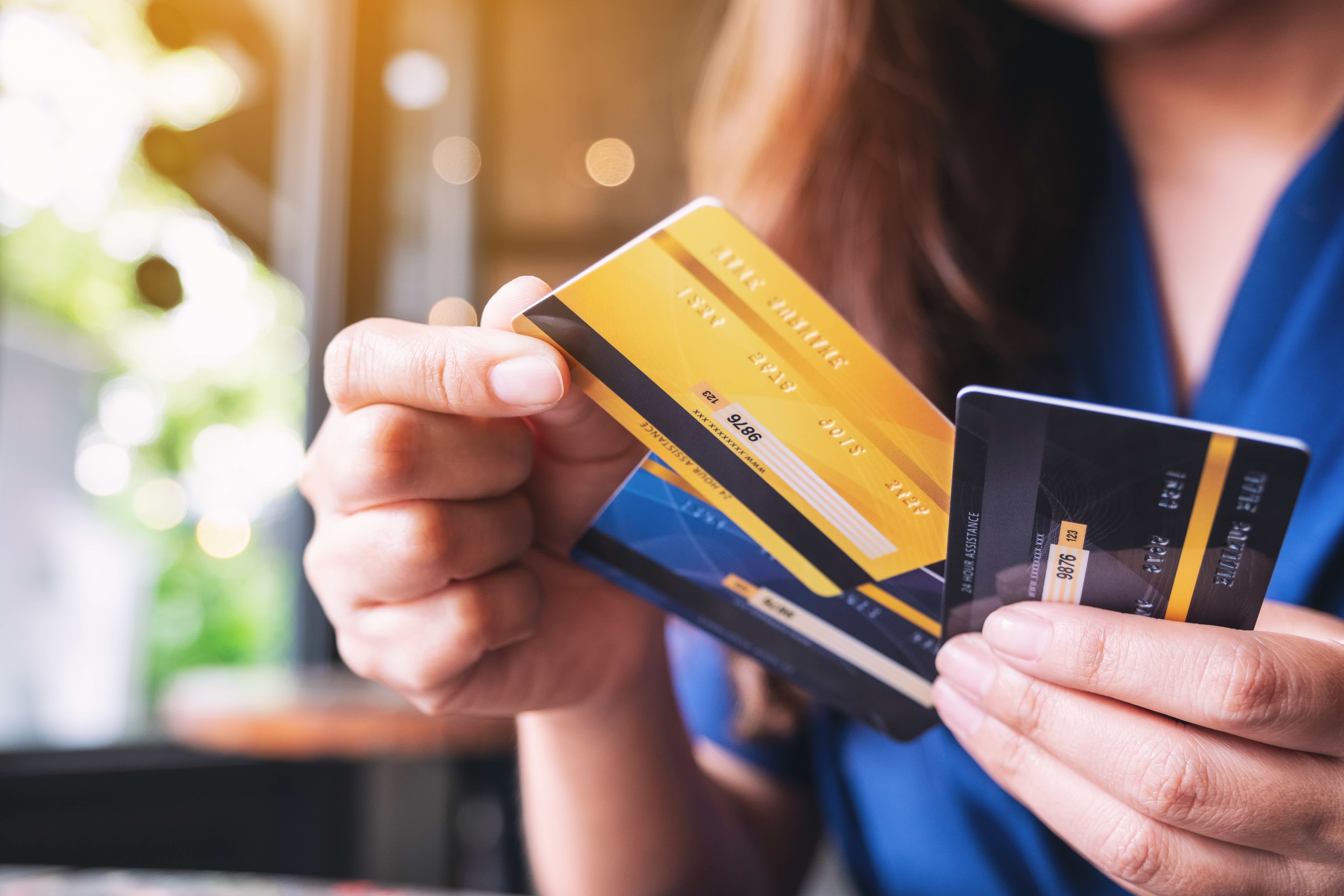 zoom of a person holding three credit cards