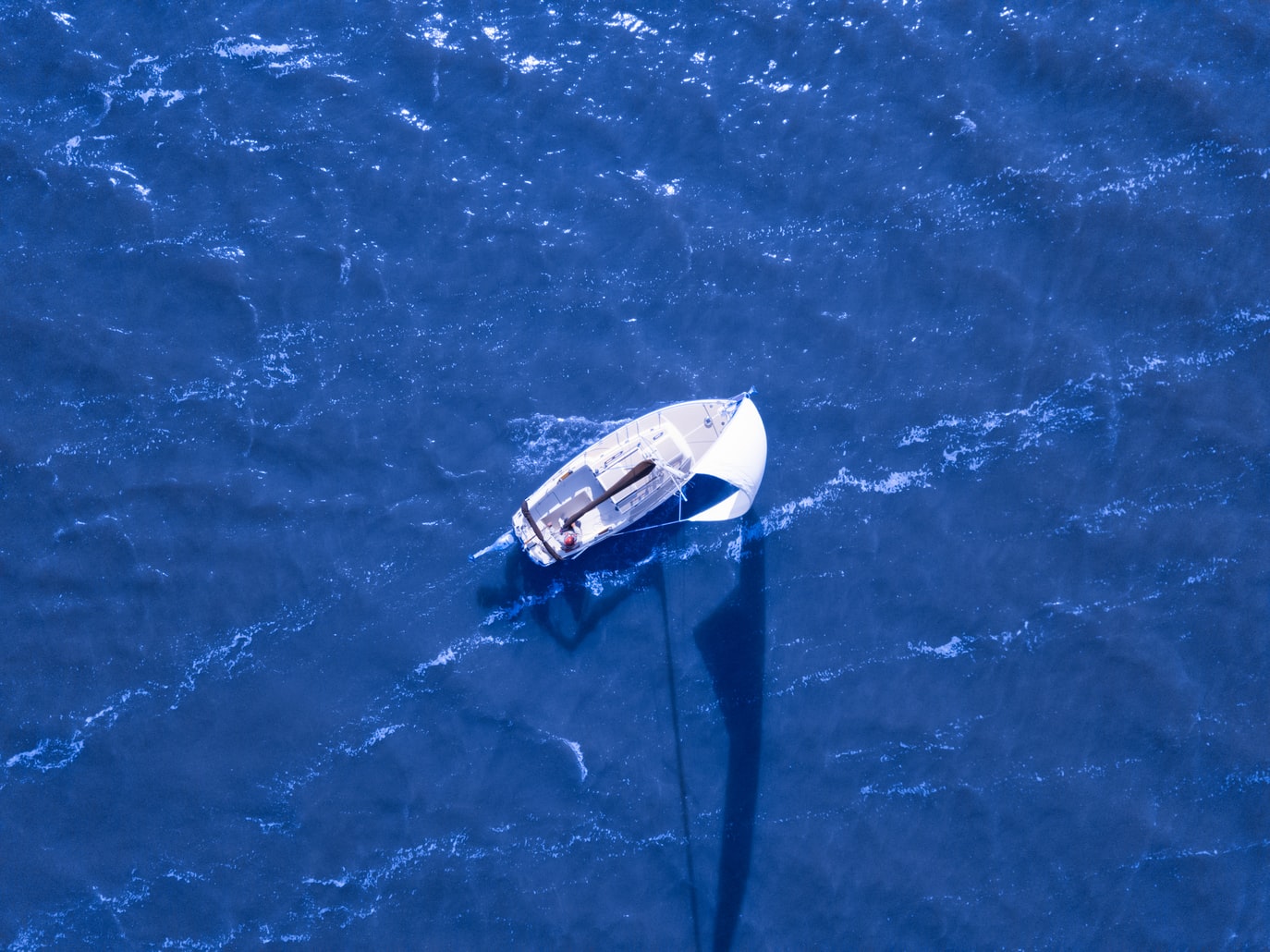Barco visto de cima em mar azul