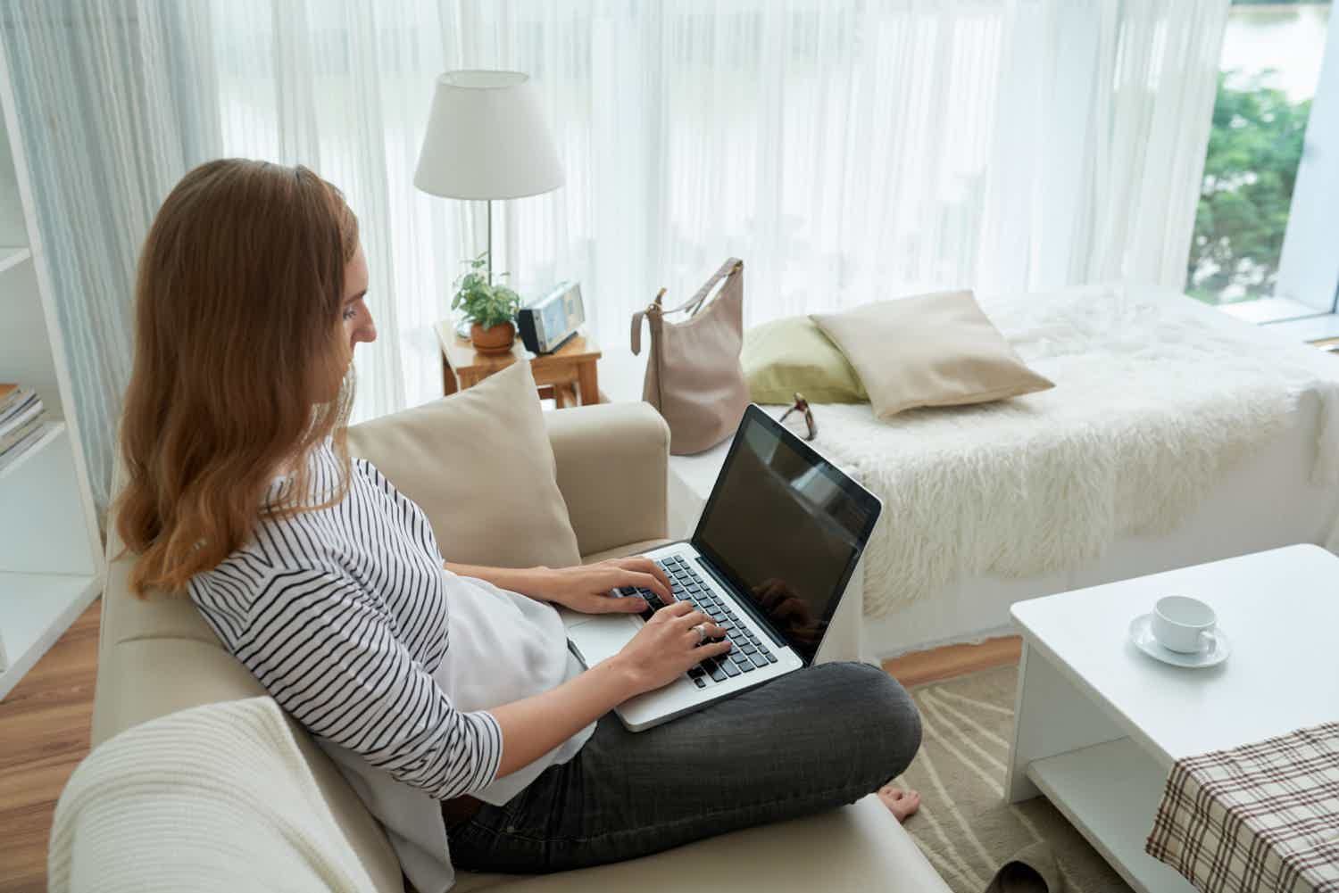 Mulher usando o notebook na sala de estar