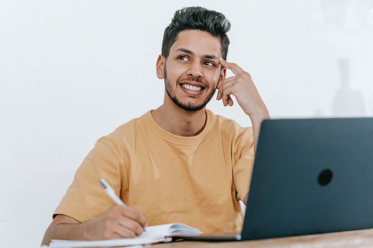Homem com camiseta amarela enquanto está estudando