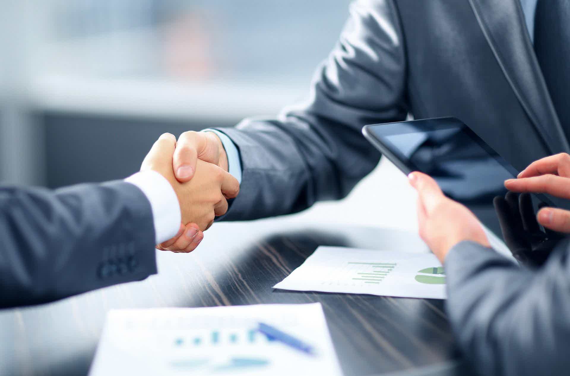 two people shaking hands on a table