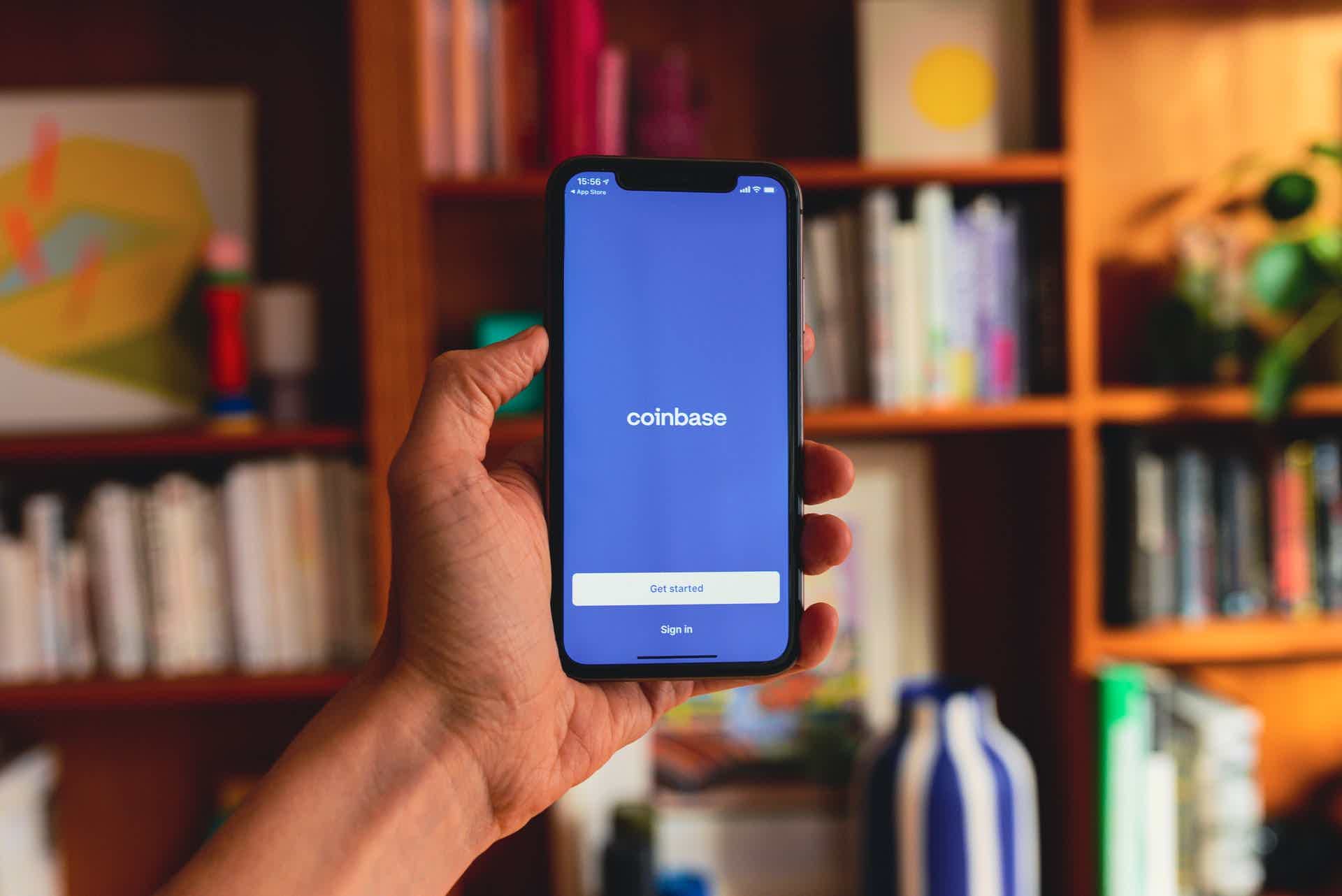 zoom of a person holding a smartphone with the Coinbase app on the screen