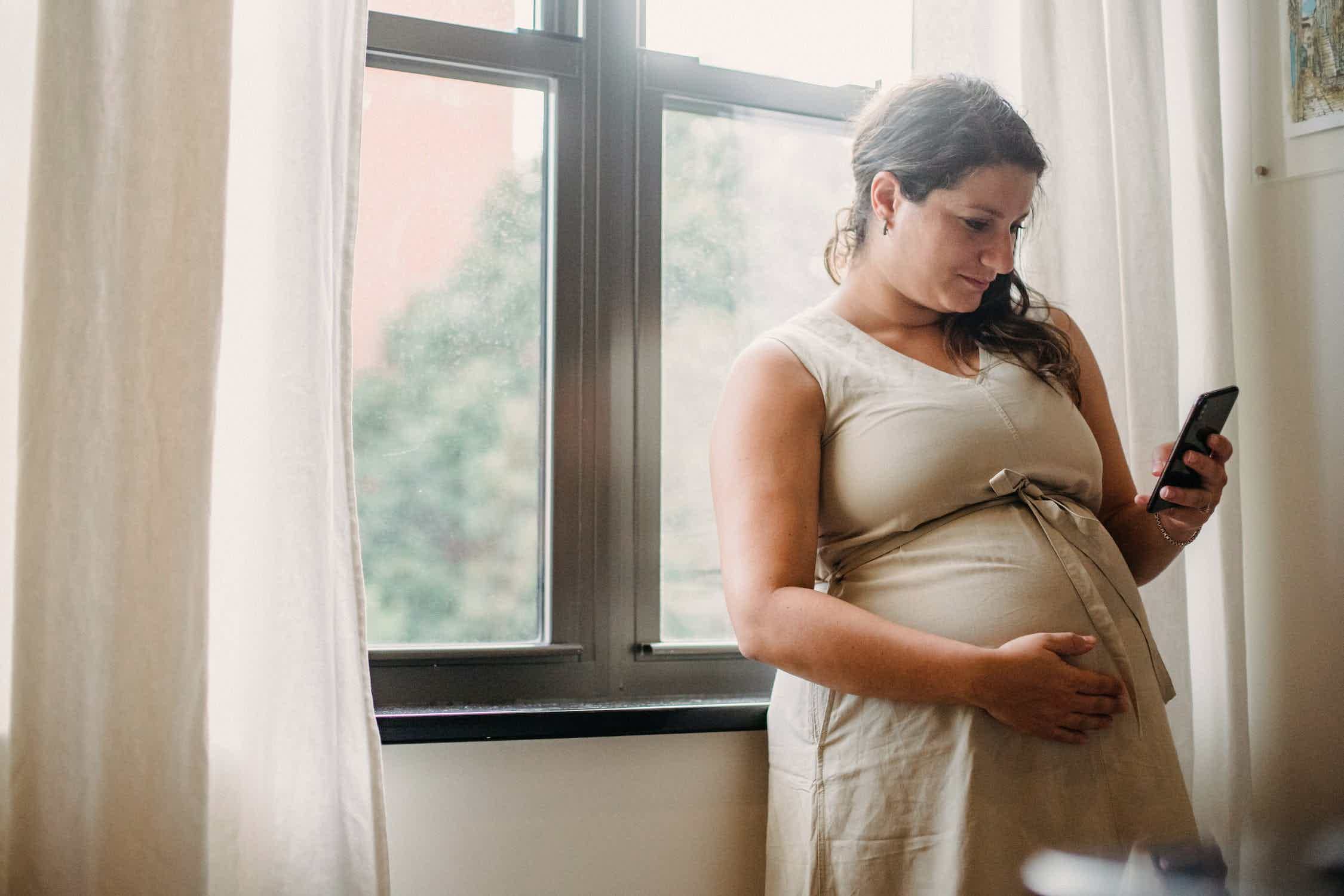 Mulher grávida usando celular