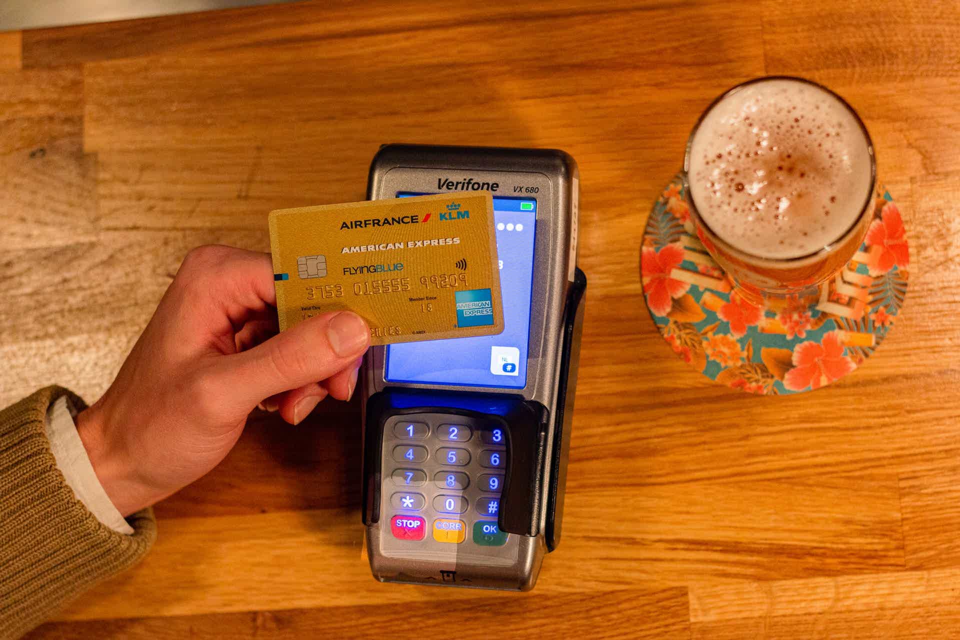 zoom of a person holding a credit card in front of a credit card machine